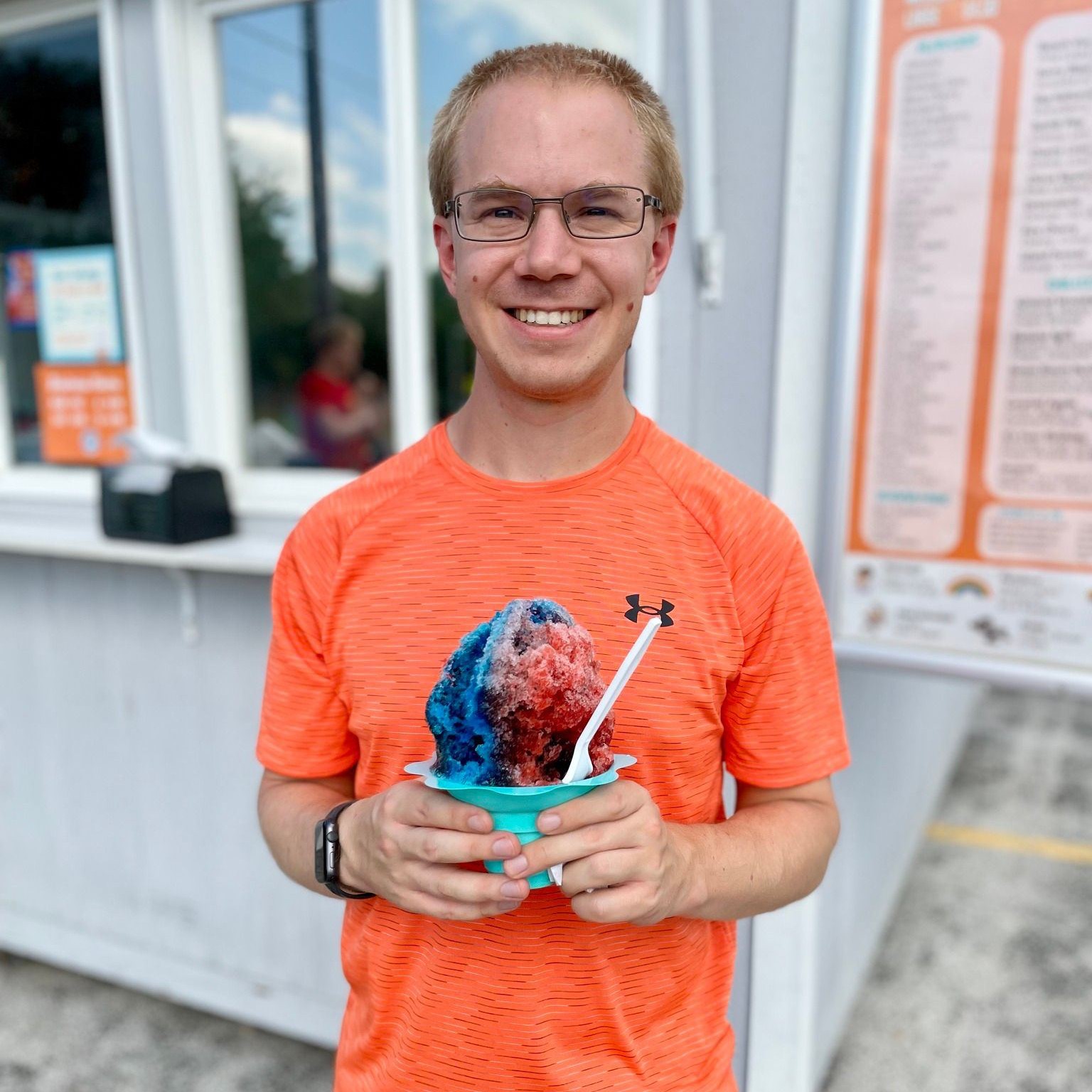 Smiling customer with red, white, blue shaved ice